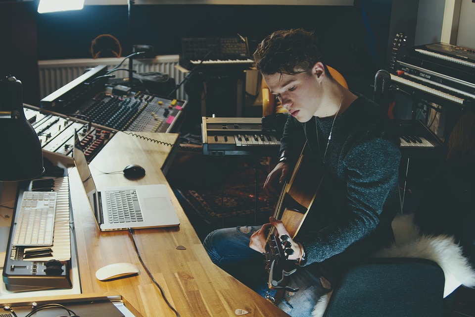 A young music producer playing guitar.